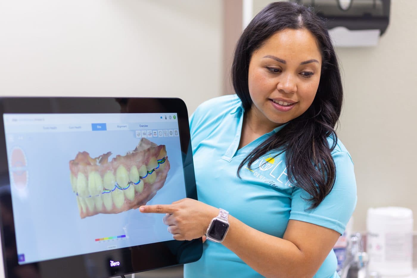 Dr. Diana Vazquez pointing to a 3D digital scan of a patient's teeth on a screen