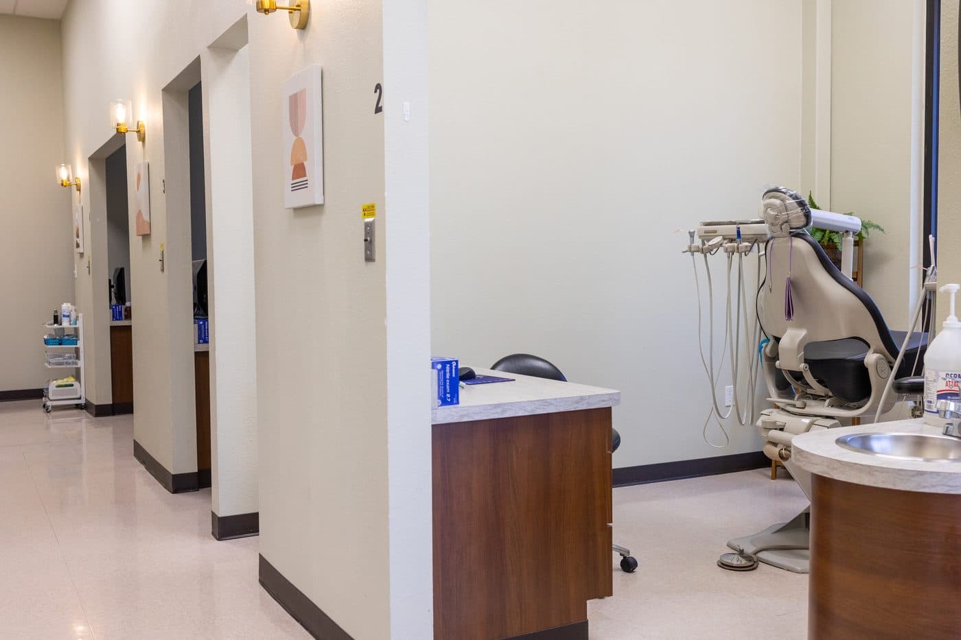 El pasillo de los consultorios de Soleil Dental Mesquite, con un sillón dental en el cuarto de la derecha