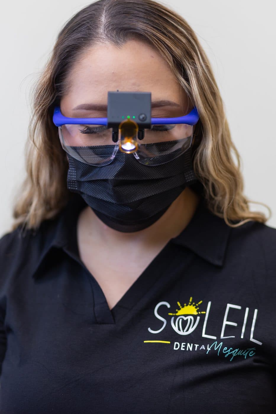 Una integrante del equipo de Soleil Dental Mesquite con lupas de aumento y luz