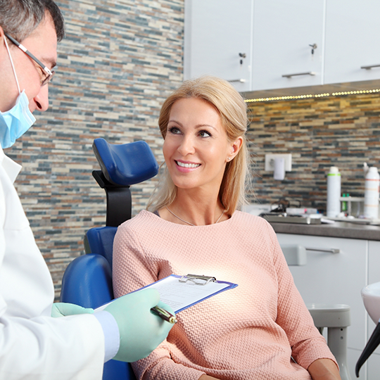 Woman smiling while listening to her Cigna dentist in Mesquite