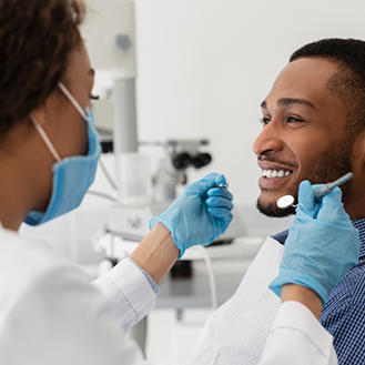 Man smiling at his dentist during a checkup