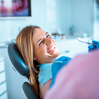Woman grinning at her dentist during a checkup