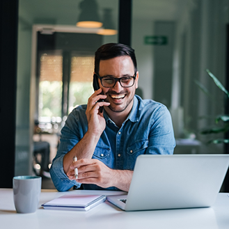 Man smiling while talking on the phone