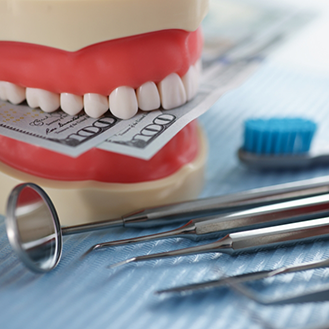 Dentures with hundred dollar bills between the upper and lower teeth