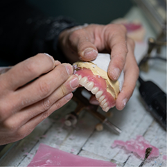 Dental lab worker adjusting a denture