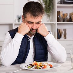 Man pouting at the dinner table