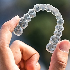 Fingers holding Invisalign outside
