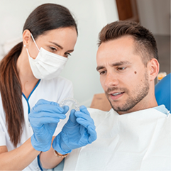 Dentist showing Invisalign to a man in the dental chair