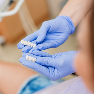 Dentist holding two dental bridges in their hands