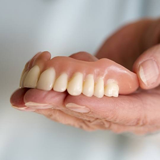 Dentist holding a full denture
