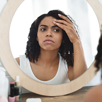 Frustrated woman looking in a mirror