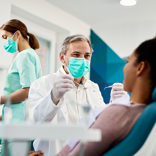 Dentist talking to a patient in the treatment chair about dental services in Mesquite
