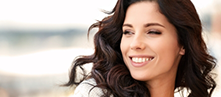 Woman with long wavy black hair smiling