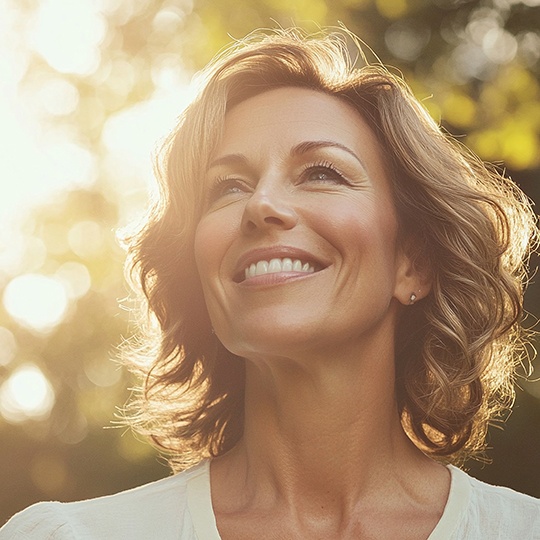 Beautiful middle-aged woman smiling in the sunlight