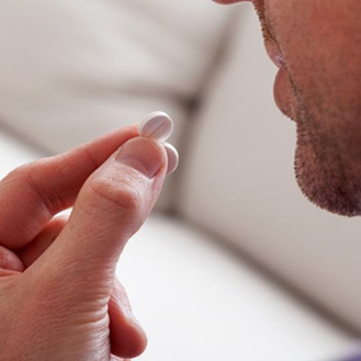 Man taking a white pill