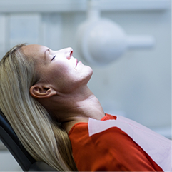 Woman relaxing in the dental chair with her eyes closed