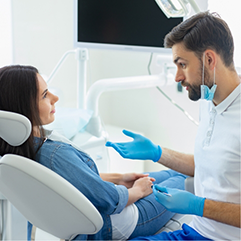 Woman in the dental chair listening to her dentist