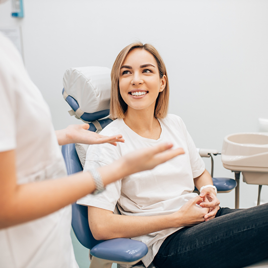 Woman sitting in the dental chair and listening to her dentist