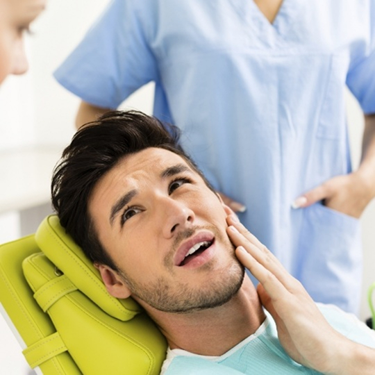 Man holding the side of his jaw in pain while visiting his dentist for T M J treatment in Mesquite
