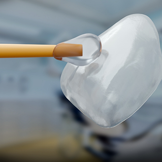 Close up of adhesive material being applied to a veneer