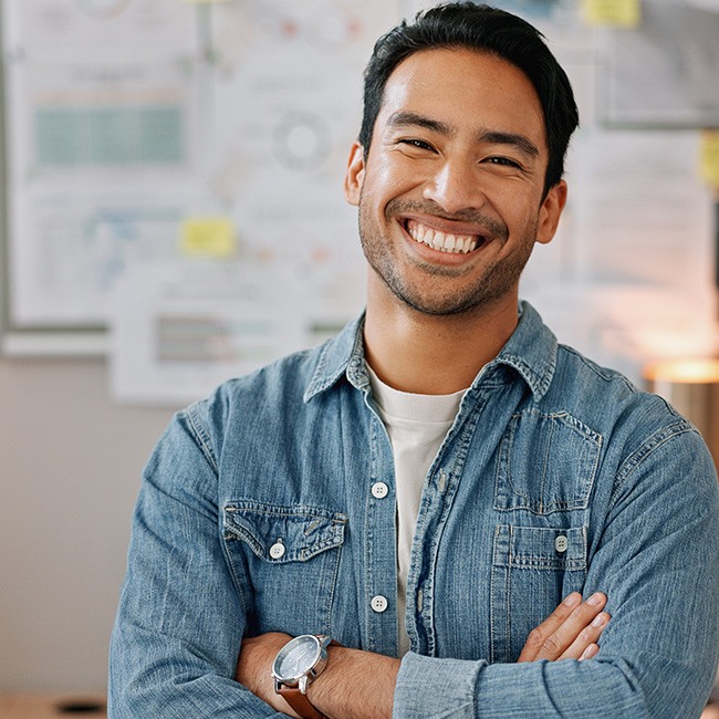 Man in denim shirt smiling in office