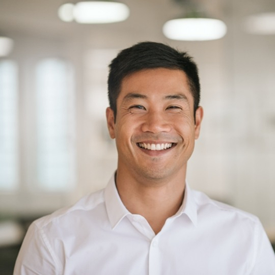 Man in white shirt smiling after wisdom tooth extractions in Mesquite
