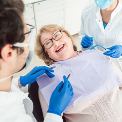 Woman with glasses smiling at dentist during consultation