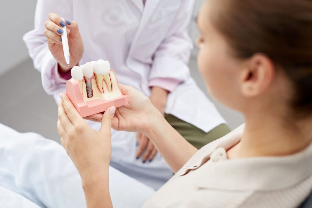 A dentist showing a patient a model of a dental implant.