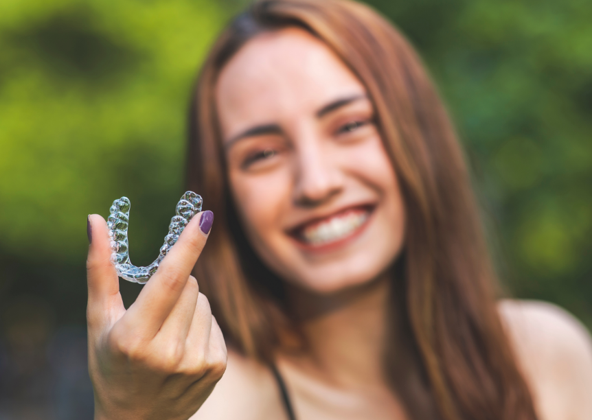 Woman holding clear aligner